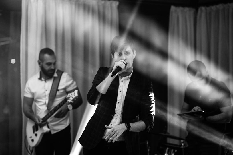 One of the Vocal Teachers Near Me Maria Drost has a young male student performing with two bandmates at the Confident Sing festival
